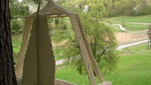 A hanging chair with a woven seat and backrest, suspended from a tree. - Holiday house for rent in the vineyards (Ptuj)