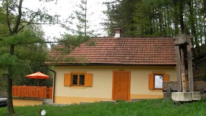 A house with a tiled roof, wooden shutters, and a small porch. - Holiday house for rent in the vineyards (Ptuj)