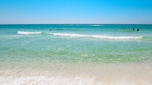 A beach with clear turquoise water and a sandy shore.