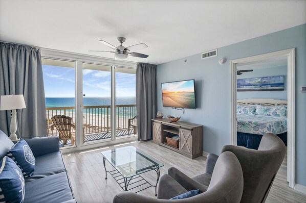 A modern living room with a glass coffee table, sofas, and a TV on the wall. - Unobstructed Ocean View ,2 bedroom , 12th Floor Pelican Beachfront  (destin)