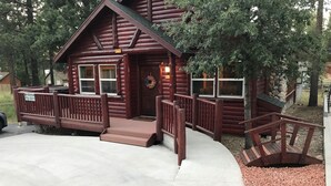 A wooden cabin with a porch, a front door, and a mailbox. - Accessible Cabin, Hot Tub, Private Dog Park & EV Charger (Big Bear Lake)