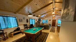 A spacious living room with a pool table, comfortable seating, and a high ceiling with exposed beams. - Accessible Cabin, Hot Tub, Private Dog Park & EV Charger (Big Bear Lake)