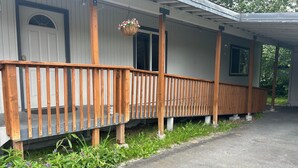A single-story house with a wooden porch and a small front yard. - Black Gold Getaway .....Walking distance to town (Valdez)