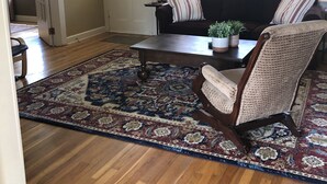 A living room with a dark brown sofa, a patterned rug, and a wooden coffee table.