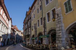 A cobblestone street lined with historic buildings, including a pub named "MILTON PUB".