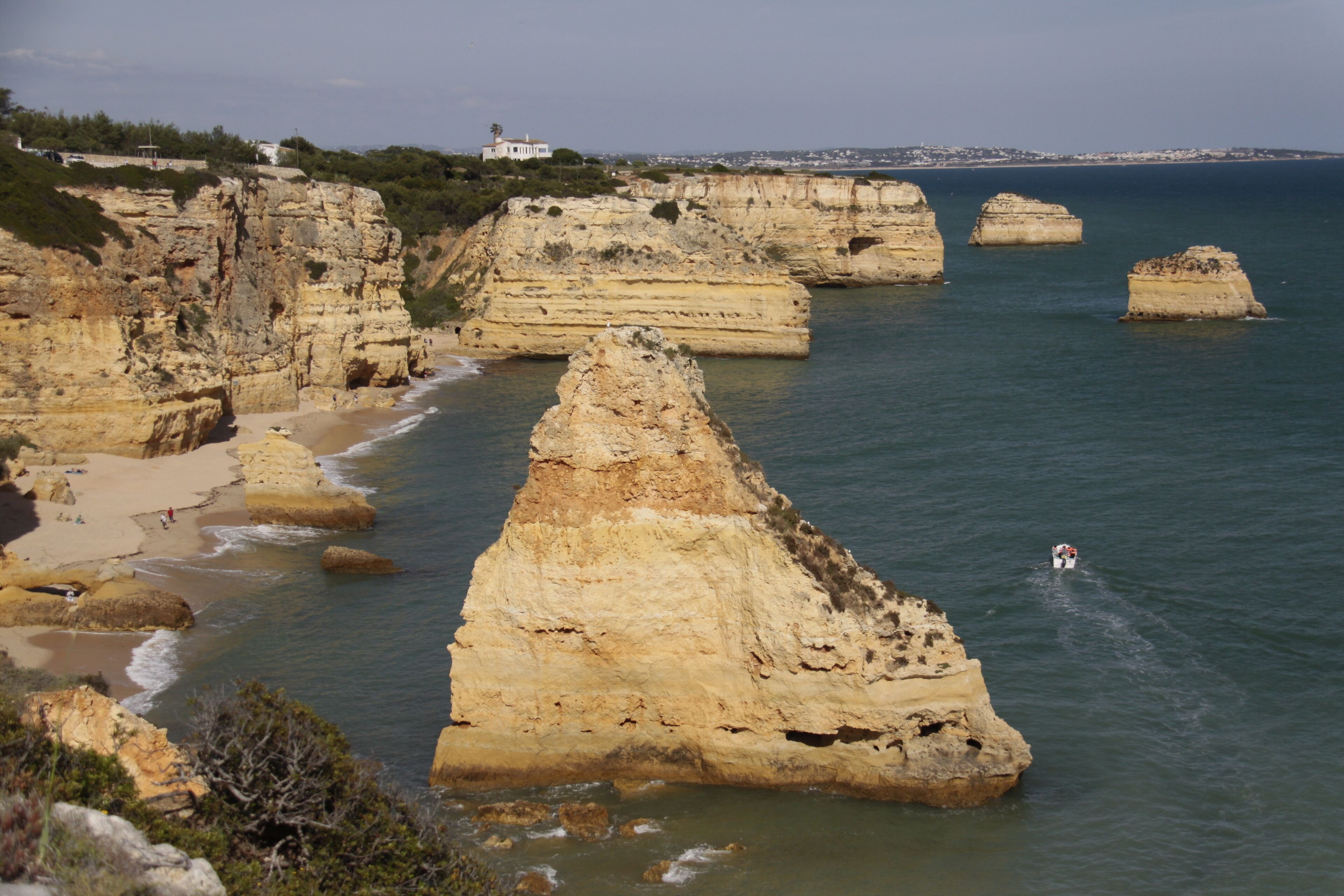 Paesaggio costiero con formazioni rocciose e una spiaggia.