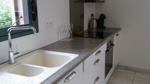 Een moderne keuken met twee spoelbakken, een vaatwasser en een roestvrijstalen afzuigkap.