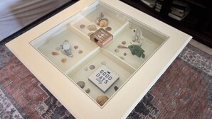 A glass-top display table with a welcome sign, seashells, a frog figurine, and a 'Good Days' card. - 4 BEDROOM HOUSE JUST A WALK TO THE BEACH! (Indian Harbour Beach)
