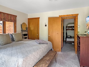 Ein Schlafzimmer mit einem Bett, einer Holzbank, einem Schminktisch und einem Kleiderschrank.
