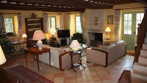 A cozy living room with a fireplace, a television, and a bookshelf. - Charming house in the park of a historic monument castle (Barbeville)