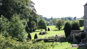 A well-maintained garden with neatly trimmed hedges, a variety of trees, and a clear view of the surrounding countryside. - Charming house in the park of a historic monument castle (Barbeville)