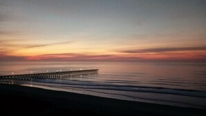 A pier extending into calm waters at sunset.