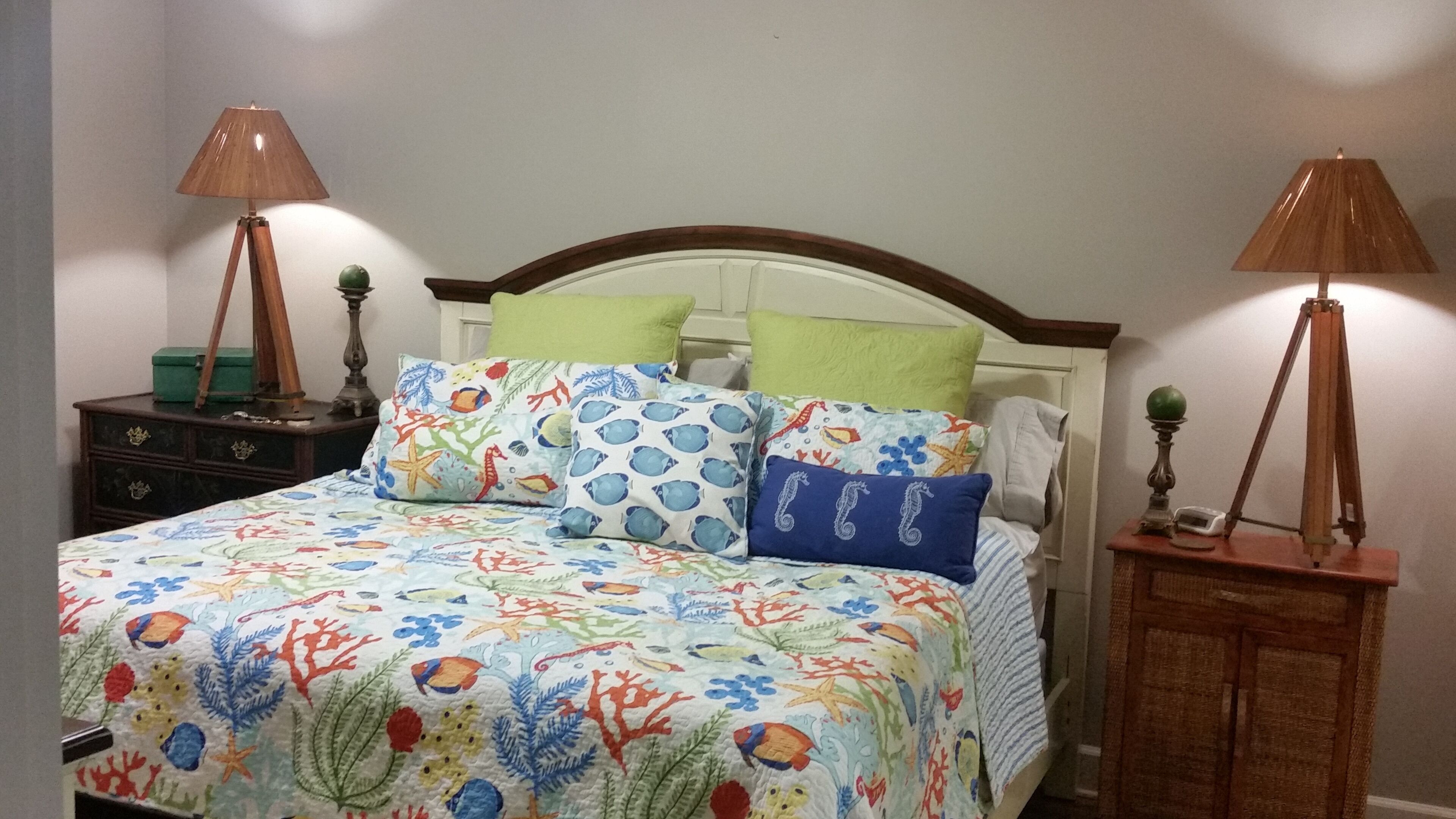 Une chambre à coucher avec un lit, des oreillers et deux tables de chevet avec des lampes.