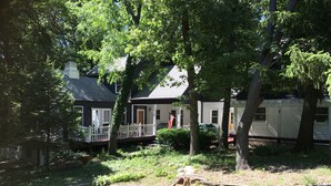 A residential area with two houses, a porch, and a lawn.
