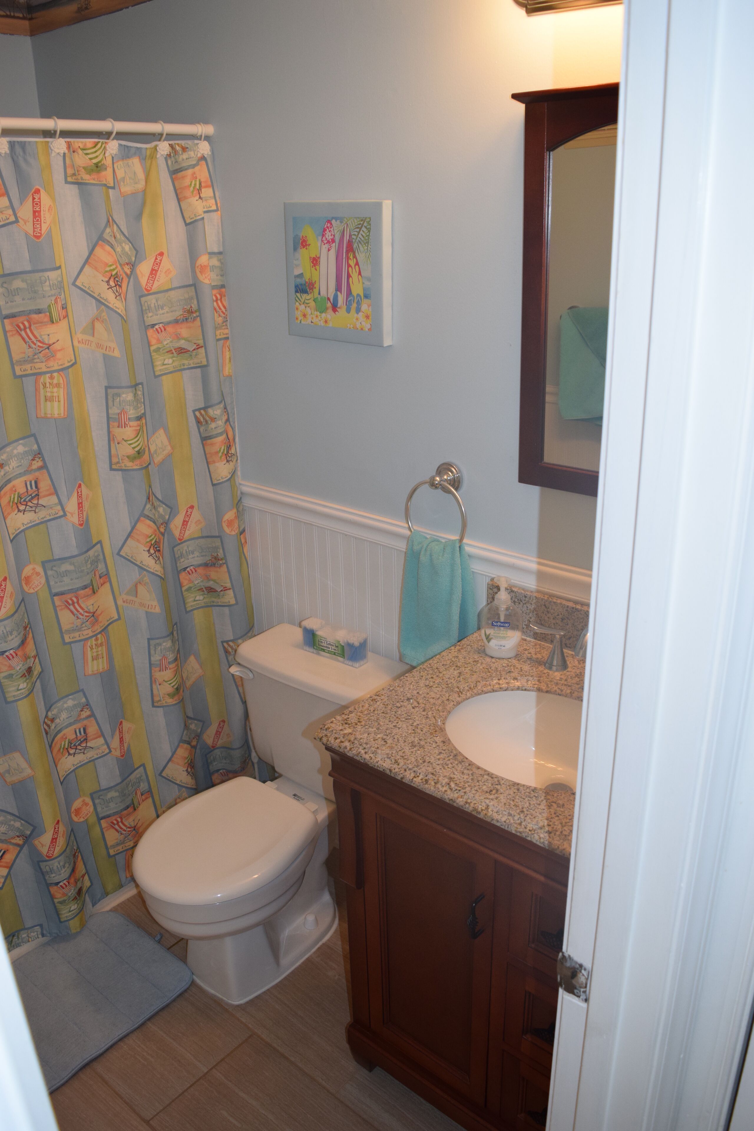 A bathroom with a toilet, sink, and shower curtain.