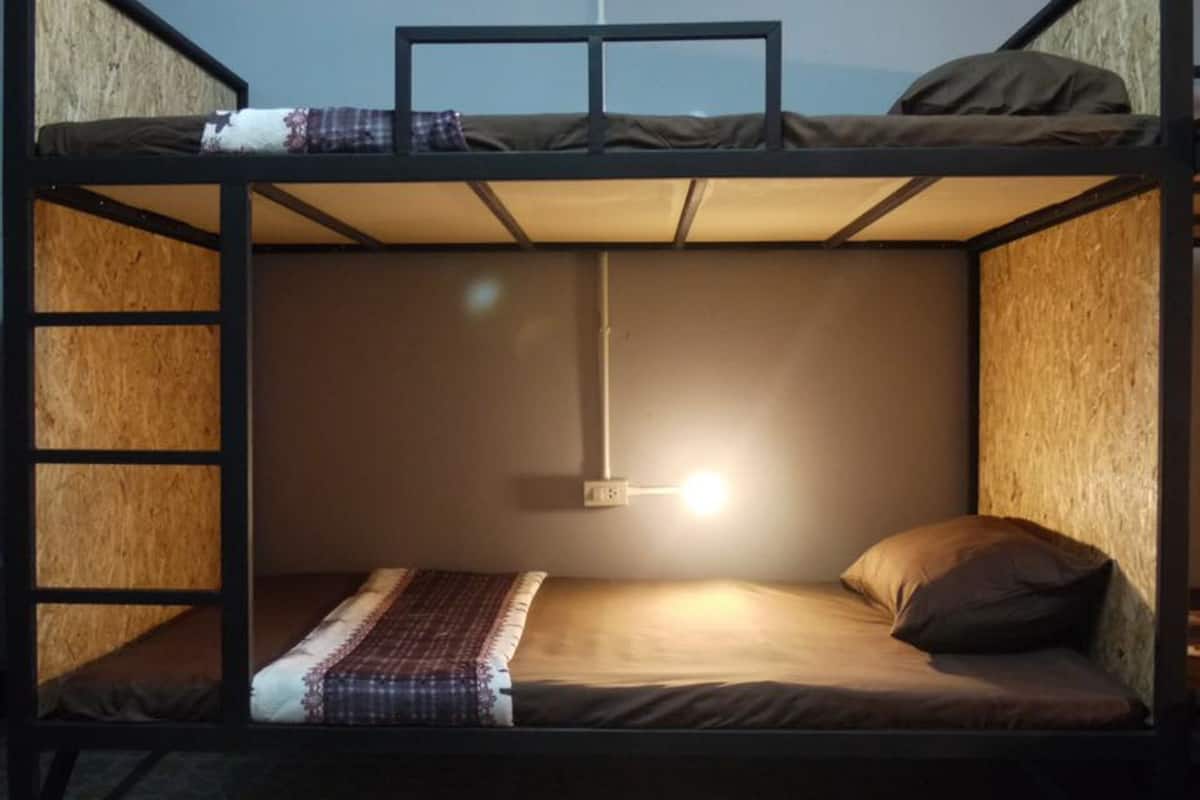 A bunk bed room with a single bed at the bottom and a bunk bed above.