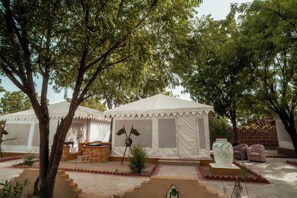 Un terrain de camping avec des tentes, un drapeau et un vase décoratif.