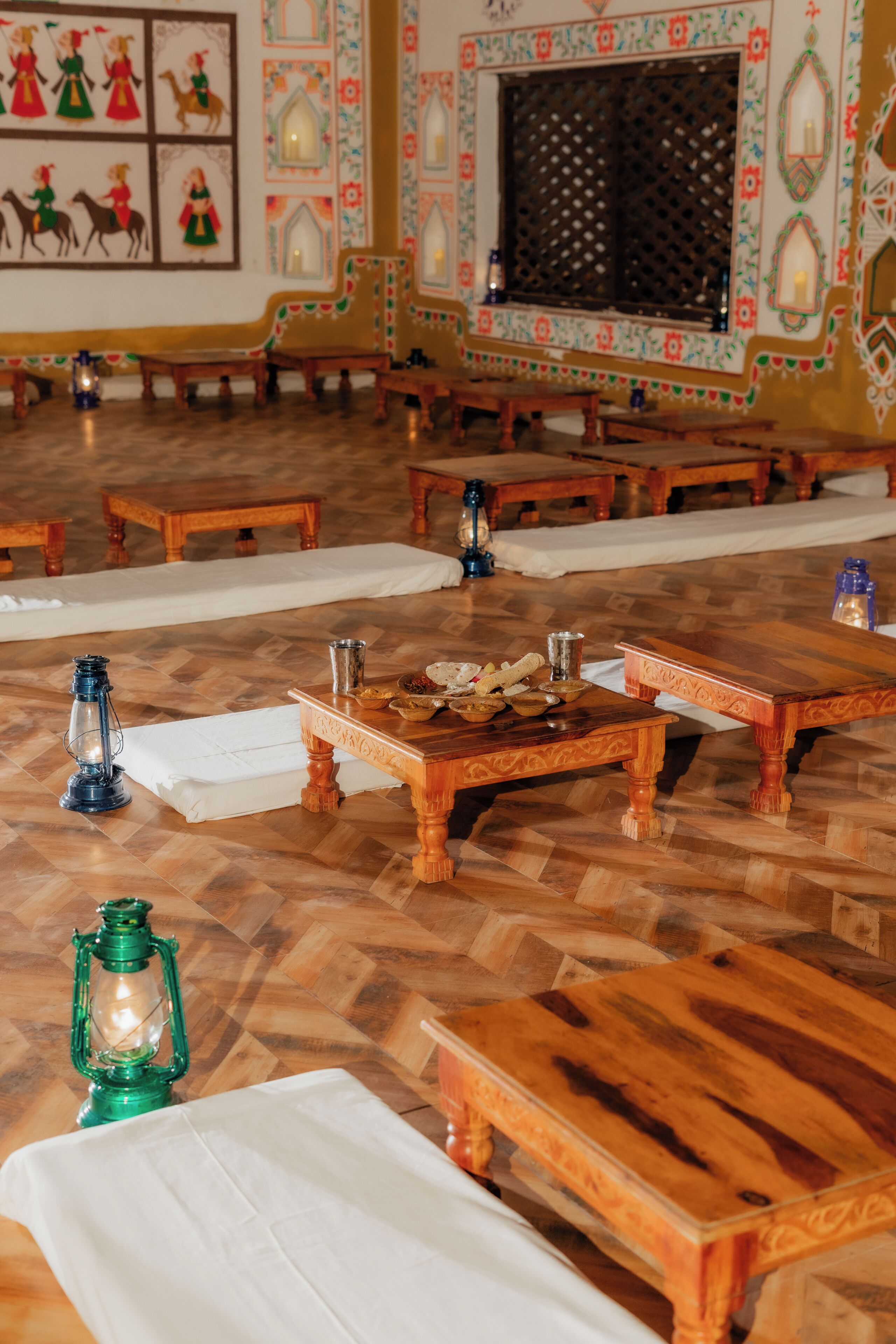 A traditional room with wooden furniture, a patterned wall, and a large window.