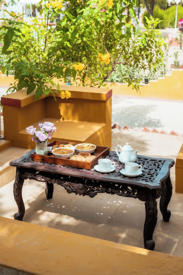 A table with a tray of food and tea set.