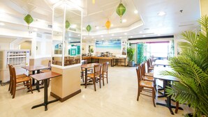 A restaurant with a high ceiling, pendant lights, and a view of the sea through large windows. - The Warwick (Cheung Chau)