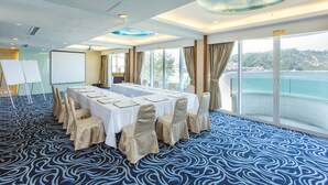 A conference room with a long table, chairs, a whiteboard, and a large window with a view of a body of water. - The Warwick (Cheung Chau)