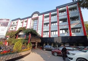 Un edificio de varios pisos con un diseño arquitectónico moderno, caracterizado por un llamativo esquema de color rojo y blanco.