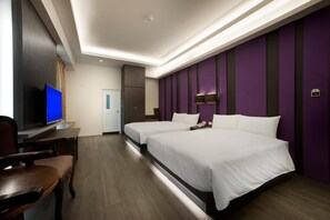 Une chambre d’hôtel avec deux lits, un bureau avec une chaise, une télévision et une armoire.
