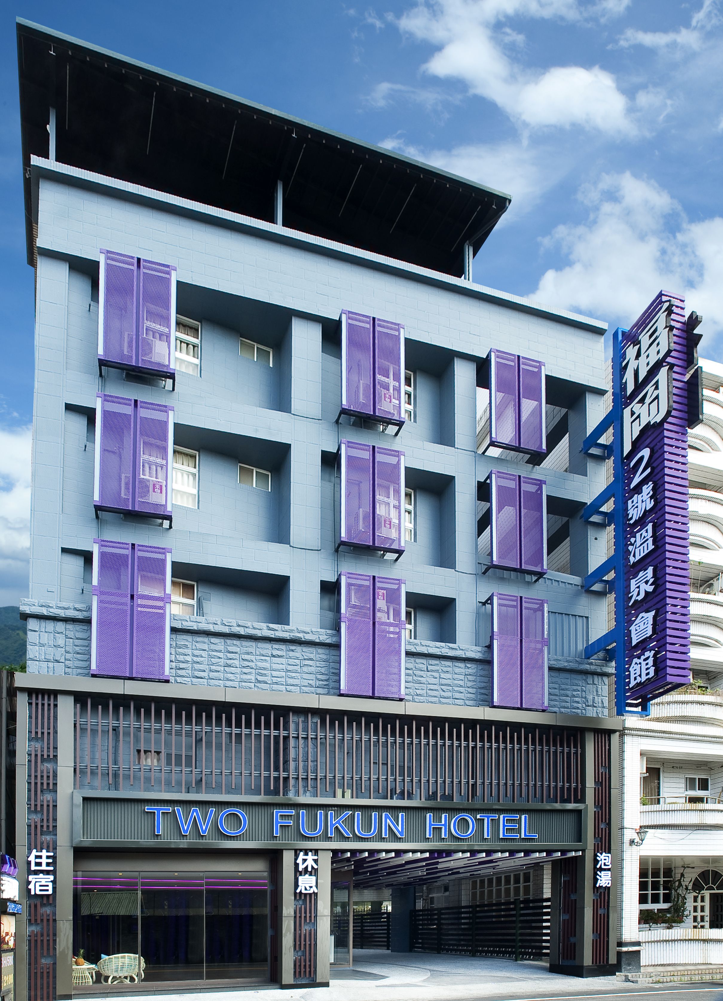 A multi-story hotel with a modern facade, featuring a prominent sign for the "TWO FUKUN HOTEL" and a vertical sign with Chinese characters.