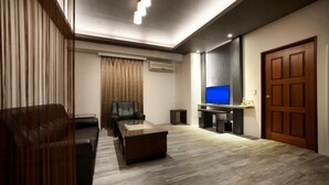 Una sala de estar moderna con un sofá, una mesa de centro, un televisor y una puerta de madera.