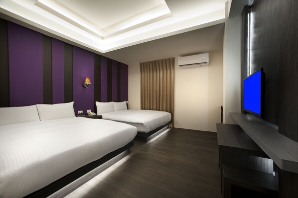 Une chambre d’hôtel avec deux lits, une télévision et un appareil de climatisation.