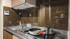 Una cocina moderna con encimera de granito, electrodomésticos de acero inoxidable y salpicadero con diseño moteado.