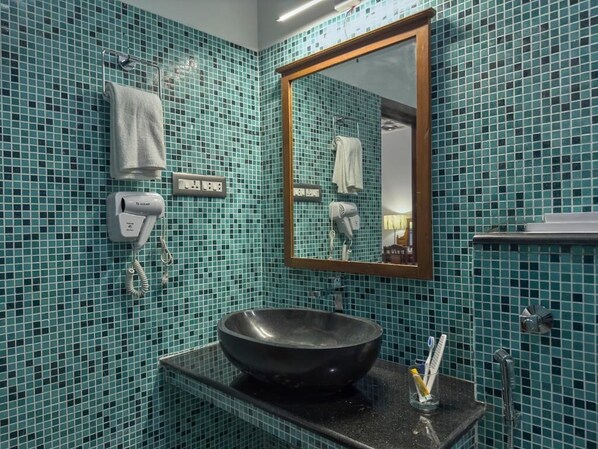 A bathroom with a large mirror, a black sink, and a towel rack.
