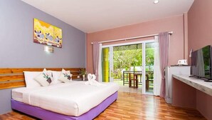 A hotel room with a large bed, wooden headboard, a TV, and a balcony with a table and chairs. - Greenery Resort Koh Tao (Koh Tao)
