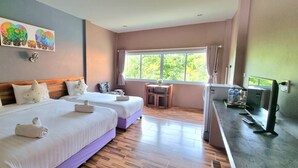 A hotel room with two beds, a desk, a TV, and a window with a view of trees. - Greenery Resort Koh Tao (Koh Tao)