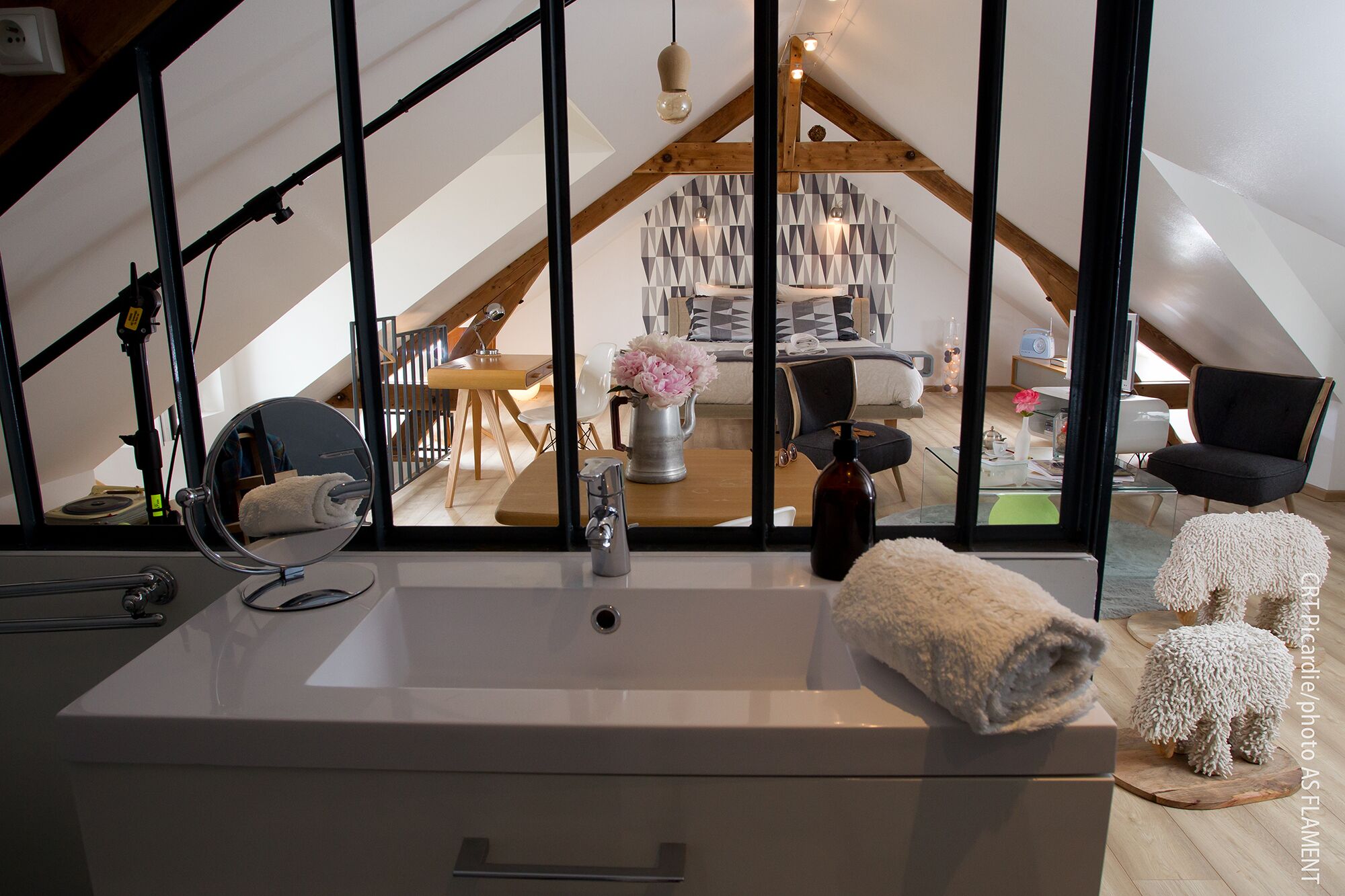 A modern bathroom with a sink, mirror, and towel.