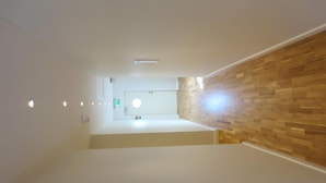 A hallway with a wooden wall and a white door at the end. - Norrskedika hotell - Gamla Järnhandeln (Osthammar)