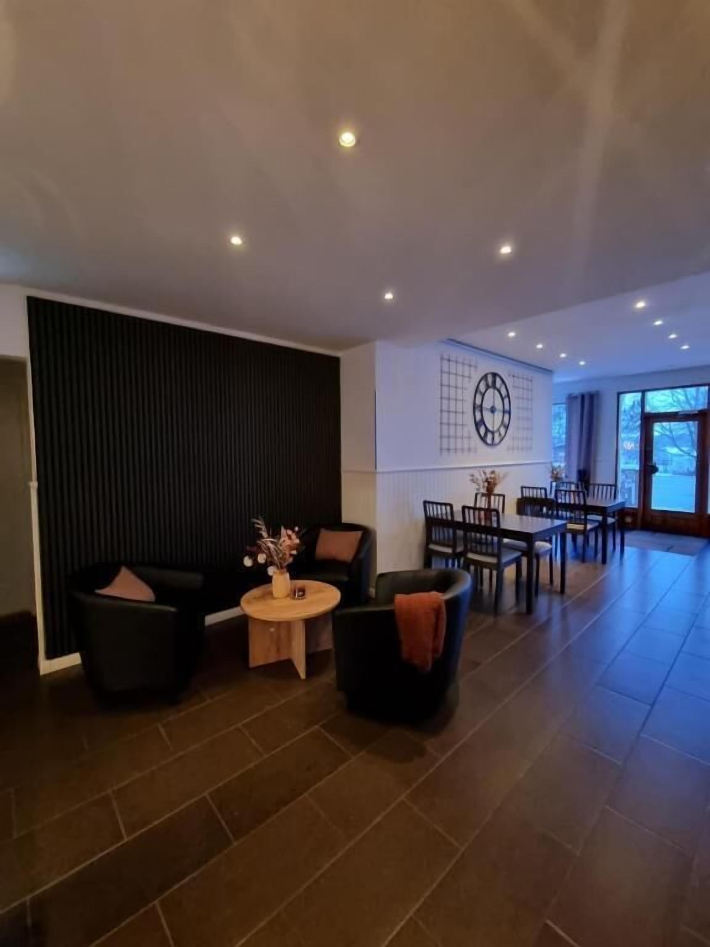 Ein modernes Wohnzimmer mit einer Sofagarnitur, einem Couchtisch und einem Esstisch mit Stühlen.
