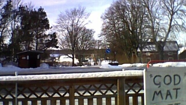 A snowy outdoor area with a wooden fence and a sign that reads "GOD MAT". - Norrskedika hotell - Gamla Järnhandeln (Osthammar)
