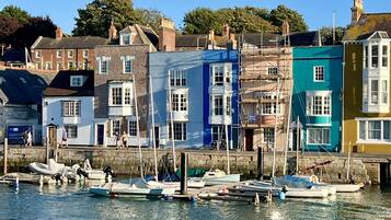 Une promenade en bord de mer, avec des bâtiments aux couleurs vives et des bateaux amarrés.