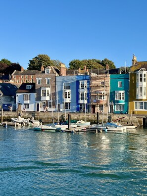 A waterfront with colorful buildings and boats docked. - Oaklands Guest House (Weymouth)