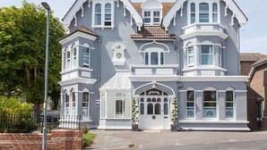 Ein großes, zweistöckiges Gebäude mit einer symmetrischen Fassade, zahlreichen Fenstern und einem zentralen Eingang.