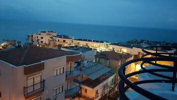 A coastal residential area with multi-story buildings, balconies, and a view of the sea.