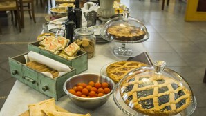 A buffet table with various food items including pies, sandwiches, and a bowl of fruit. - Albergo Bellavista (Lamporecchio)