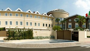 A hotel with a curved facade, a central dome structure, and a gated entrance. - Hotel Morgana (Rodengo-Saiano)