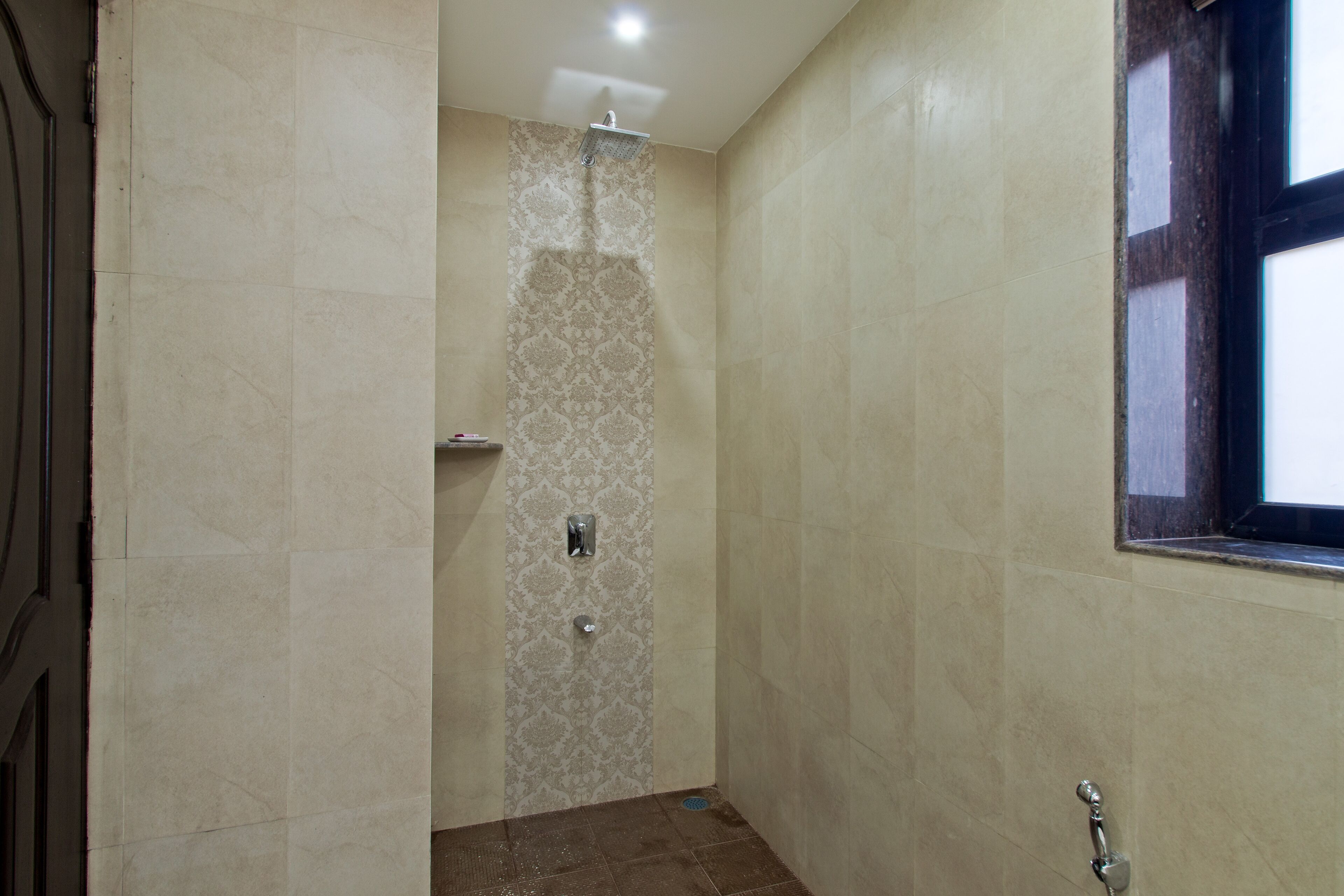A bathroom with a shower, tiled walls, and a window.