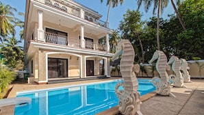 A two-story building with a swimming pool and decorative seahorse sculptures. - Villa Calangute Phase 10 (Calangute)
