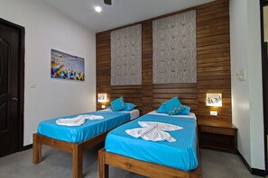 A hotel room with two beds, wooden headboards, and wall-mounted light fixtures. - Villa Calangute Phase 10 (Calangute)