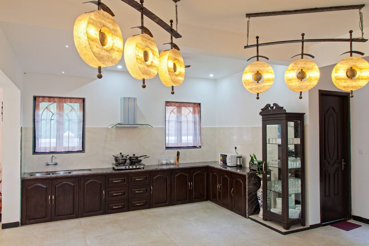 A modern kitchen with dark wooden cabinets, a built-in stove, and a large window with a view.