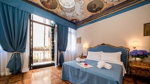 A hotel room with a large bed, a nightstand, a lamp, and a view of the outside balcony. - Ca' Lavezzera (Venice)