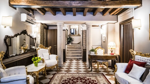 A luxurious room with ornate furniture, a checkered floor, and a staircase leading to another area. - Ca' Lavezzera (Venice)